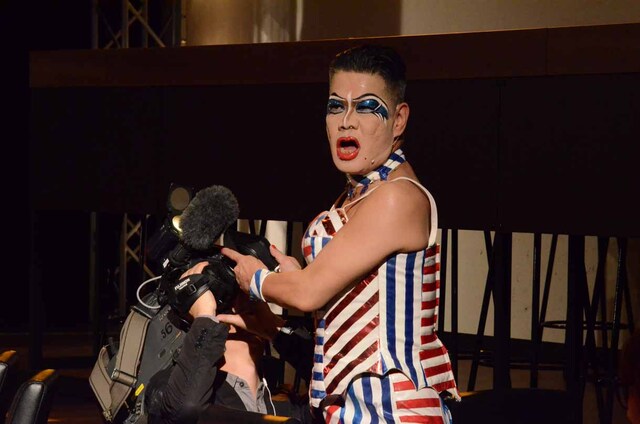 カメラマンに豆を噴射しようとする梅垣義明。