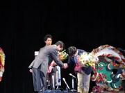 母袋市長から花束を受け取る劇団ひとり。