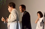 帽子を取って舞台挨拶中の記念撮影にフレームインするマキタスポーツ(中央)。