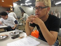 真剣な表情で芸人たちの稽古を見つめる亮。