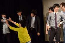 「丸1日10公演耐久ライブ」のMCがくじ引きでザンゼンジに決まり、K-PROの児島気奈代表にすがりつくザンゼンジ武田（手前左）。