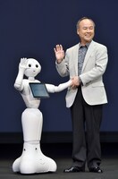 Pepperと握手をするソフトバンクグループ代表・孫正義。