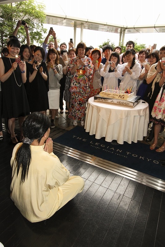 祈るジュンをありがたく写真に収める参加者たち。(c)河村正和