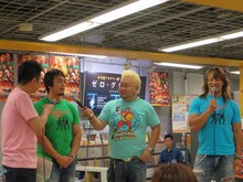 東京ダイナマイトの2人からマイクを向けられる小声の田口。