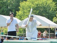 走り高跳びのバーを切ろうとするすしざんまいの社長。