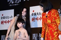 伽椰子と会話しようとする橋本扮する朱美ちゃん3号（右）。