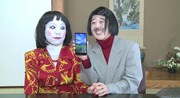 朱美ちゃん3号（左）にauスマートフォン「isai FL」をプレゼントする細貝さん（右）。