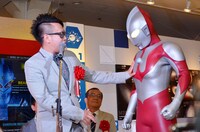 ウルトラマンのたくましい胸板を触る宮川大輔。