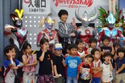 博多大吉（後方中央）とウルトラヒーロー、子供たち。(c)円谷プロ