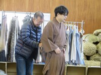 衣装を着せてもらう吉村。