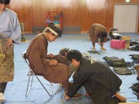 2人がかりで草履を履かせてもらう吉村。