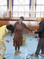 ヘトヘトの様子で2人がかりで甲冑を脱がせてもらう吉村。