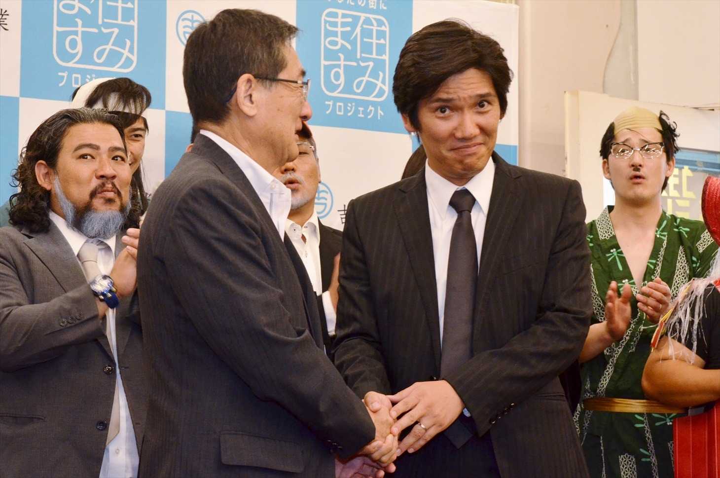 モノマネの結果、甲州市の田辺市長（手前左）によって最優秀賞に選ばれたいしいそうたろう。（手前右）。