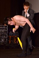 「ぐるぐるバットで30回転しても目が回らない男」を実証するエスパー伊東（手前）と、古坂大魔王（後方）。