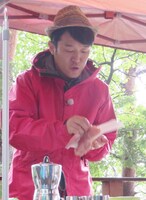 アウトドア料理をふるまうヒデ。