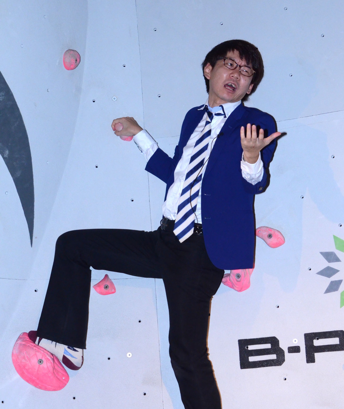 ボルダリングに挑戦しながら司会にツッコむ小宮。