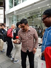 行列に並ぶ際に持参したけん玉の腕前を披露するデニス植野（中央）。