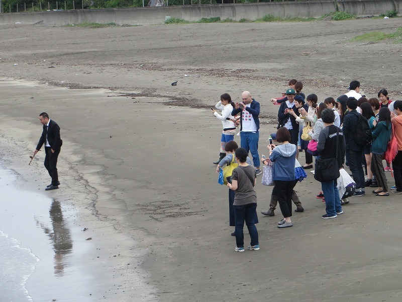 砂浜に「あるある」と刻むRGと、それをここぞとばかりに激写する参加者たち。