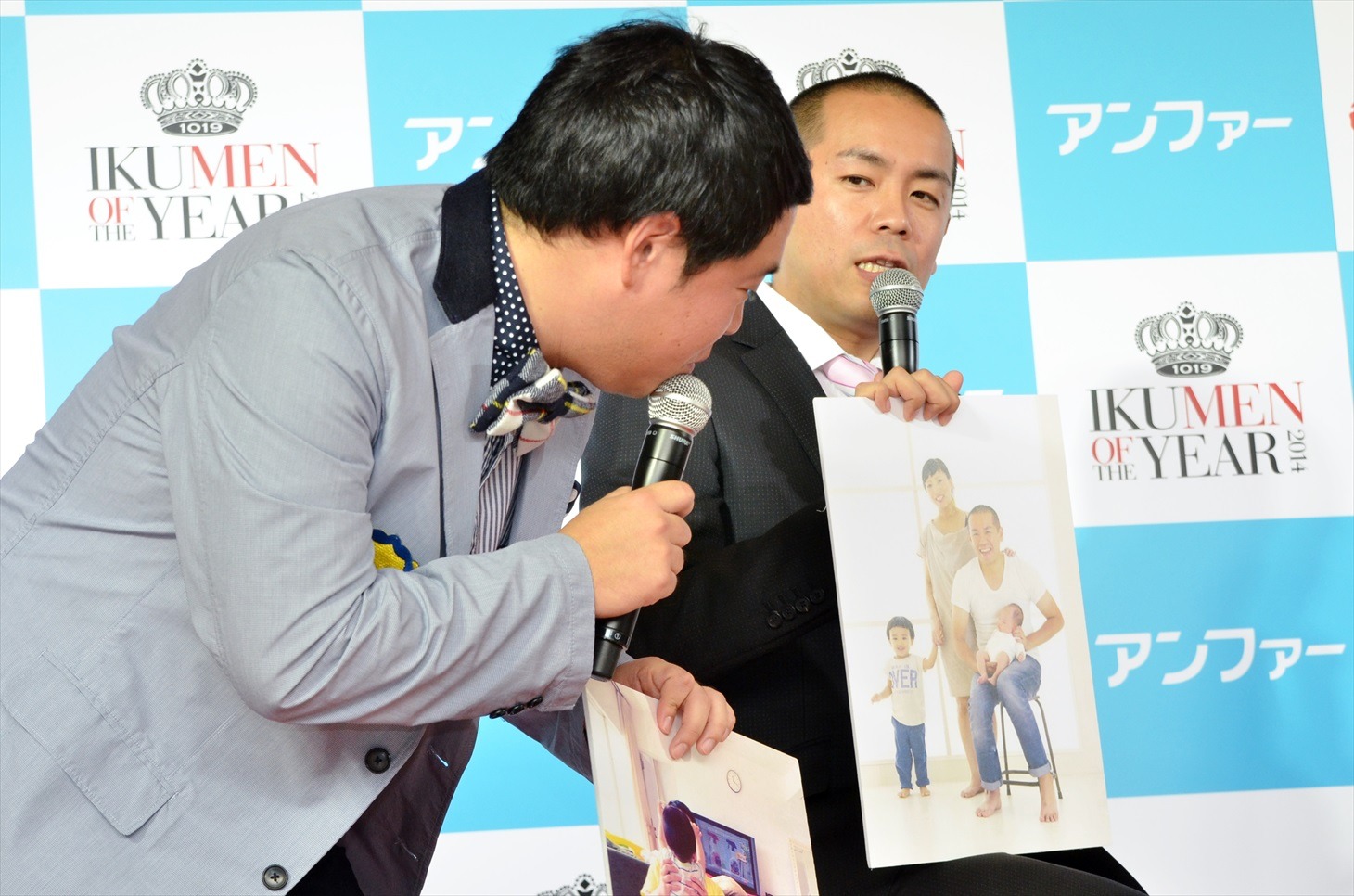 家族写真を披露するトシ（右）。