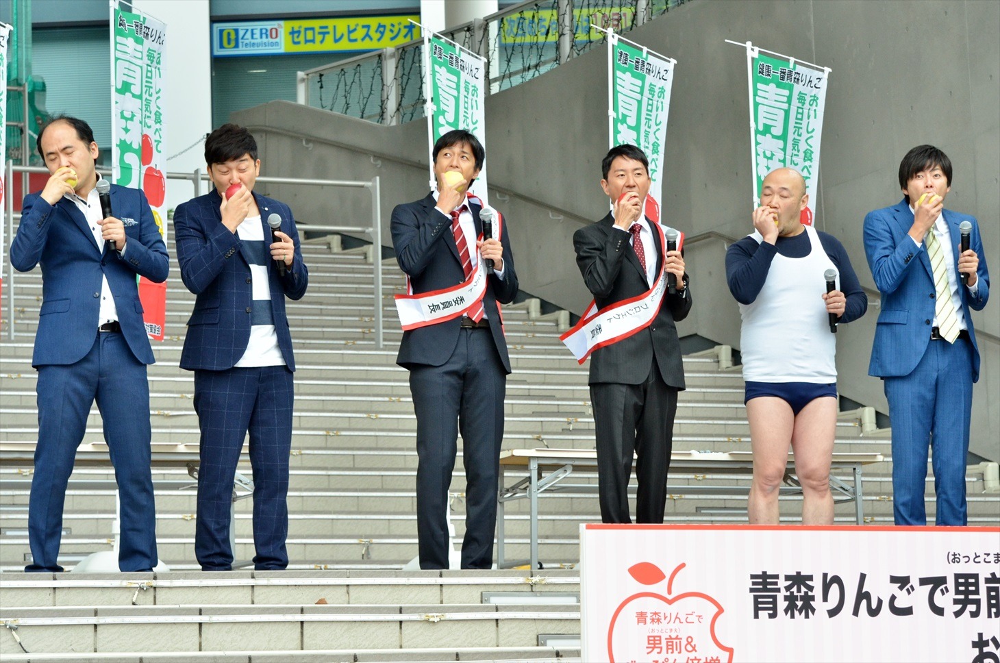 青森りんごを試食する芸人たち。