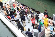 小型船に乗って水上からの中継を行った出演者たち。
