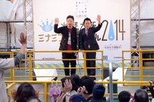 漫才中に横切る小型船の乗客に手を振るダイアン。