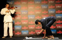 田中がバイオリンを演奏する中、書をしたためる山根（右）。