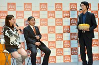 温州みかんを持参した男性の話を聞く友近（左端）と、上甲俊史・愛媛県副知事（中央）。