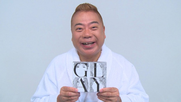 GLAYのアルバム「MUSIC LIFE」を手にする出川哲朗。