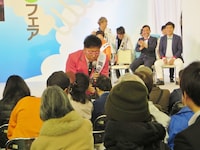 観客に湯原温泉の温泉水を配る江西。