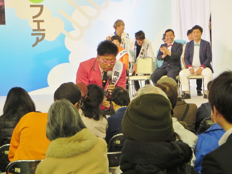 観客に湯原温泉の温泉水を配る江西。