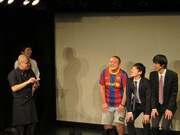 即興コント「記者会見」。記者の石田と、「ウランバートルで空から降ってきたたこ焼きを蹴り返した3人」。