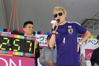 サッカーの本田圭佑選手に扮する、むらせ（右）。