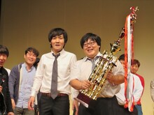 トロフィーを手に喜びの表情を浮かべるタイムマシーン3号。