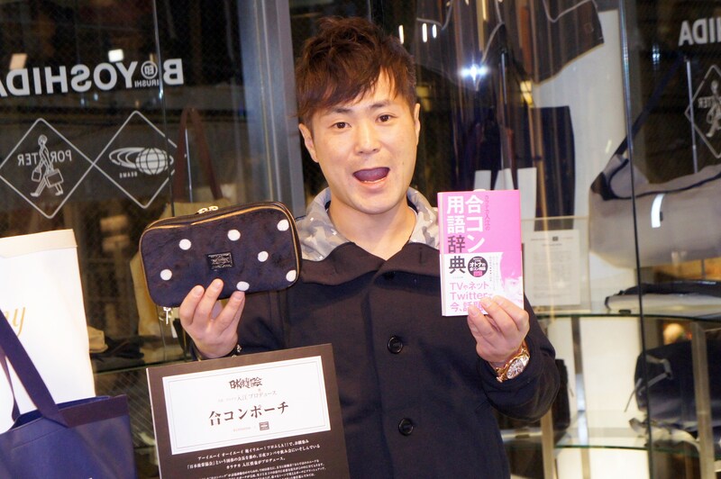 著書「カラテカ入江の合コン用語辞典」と、自身も開発に携わった「お泊り合コンポーチ」を掲げるカラテカ入江。