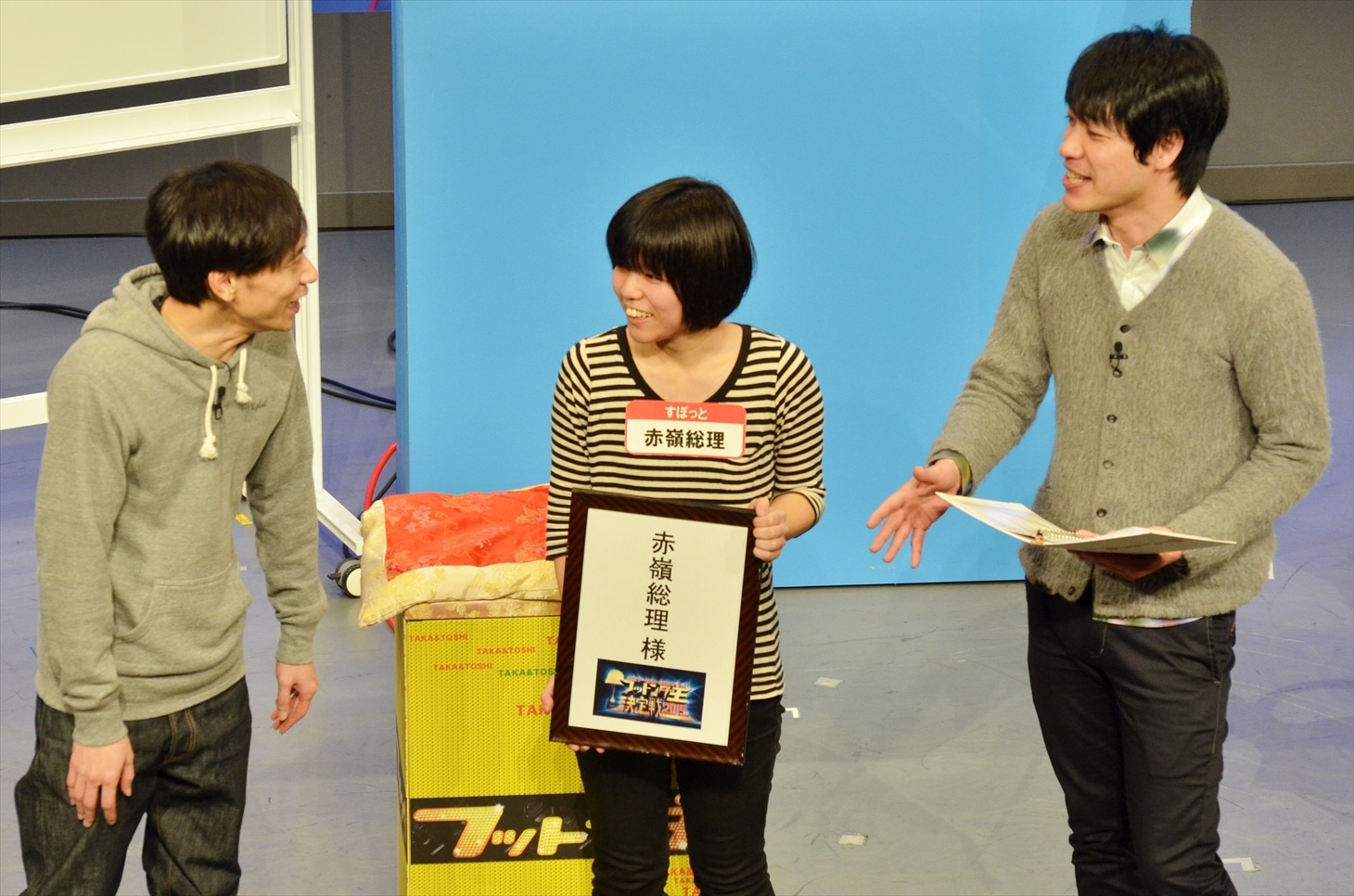「フットンダ王決定戦2015出演権争奪！芸人勝ち抜きバトル」にて優勝し、「フットンダ王決定戦2015」の出演権を獲得した、すぽっと赤嶺総理（中央）と、ライブでMCを務めた麒麟・川島（右）、インパルス板倉（左）。