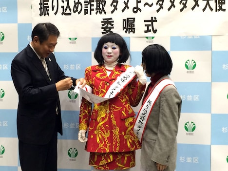 紐を区長に結んでもらう朱美ちゃん3号（中央）。