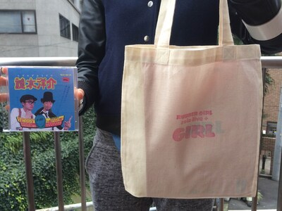 ラバーガール単独ライブ「GIRL」の会場で販売されるDVD「謎水洋介」とエコバッグ入り「GIRL」オリジナル台本。