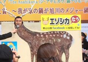 エゾシカの顔はめパネルに顔をはめるペナルティ・ワッキー。