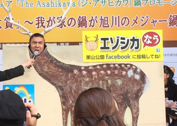 エゾシカの顔はめパネルに顔をはめるペナルティ・ワッキー。