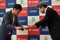 東京中央郵便局の野口局長（右）から1日郵便局長の委嘱状を手渡される、NON STYLE井上（左）。