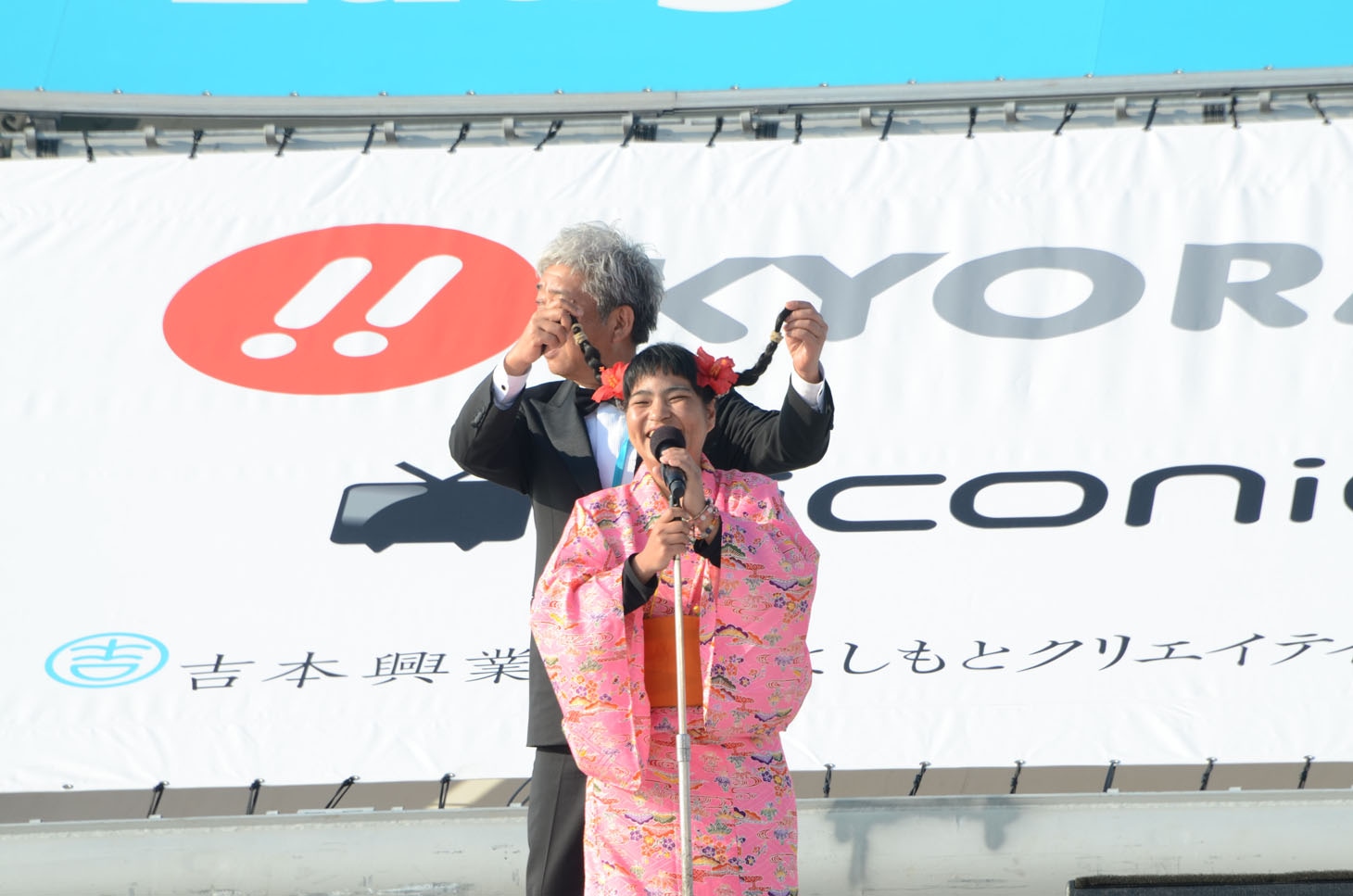 宮川たま子のおさげで遊ぶ大崎洋社長。