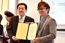 諏訪市の山田市長（左）に委嘱状を渡されたオリエンタルラジオ藤森（右）。