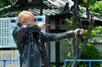 弓を引く竹中直人。