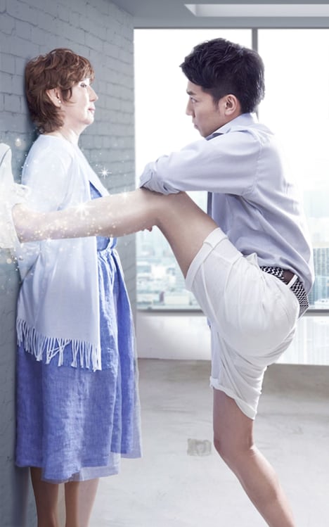 熟女に脚で壁ドンする綾部（右）。