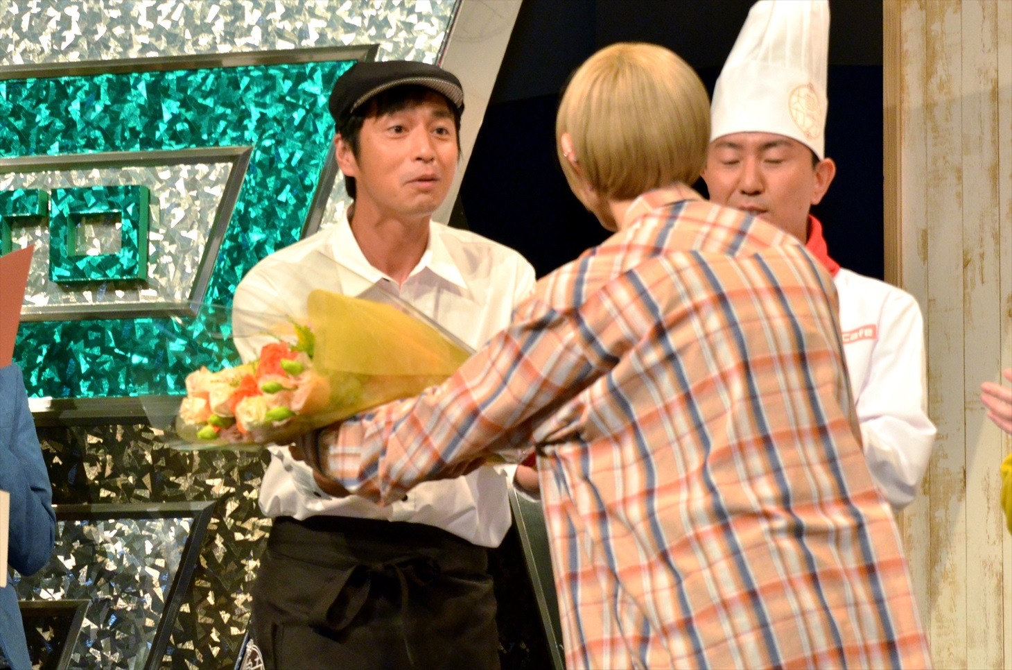 サプライズ出演した最上もが（手前）に花束を手渡されるチュートリアル徳井（左）。