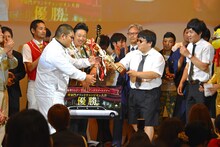 特別審査員のタイムマシーン3号からトロフィーを受け取るANZEN漫才。