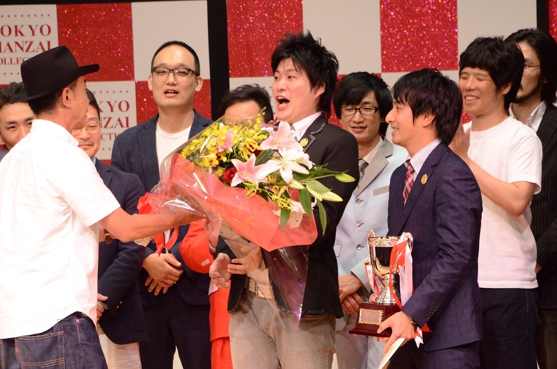 木梨憲武（左）から花束を受け取る湘南デストラーデ（右）。