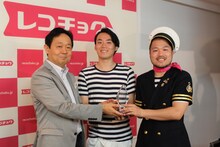 レコチョクの加藤裕一代表取締役社長からトロフィーを授与されるクマムシ（右から2人）。