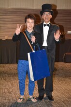 「『粘土道』不条理アートコンテスト」最優秀賞に選ばれた男性（左）と片桐仁（右）。